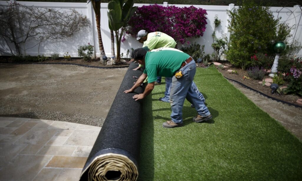 rolling-out-artificial-grass-in-yard-1