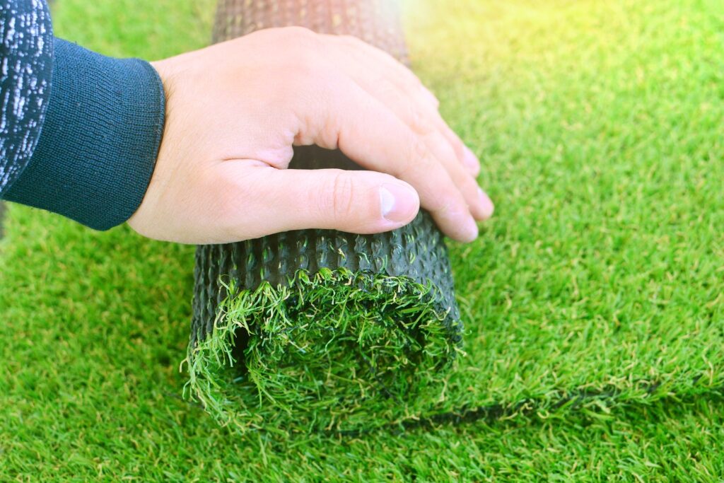 artificial-lawn-grass-with-a-hand-min