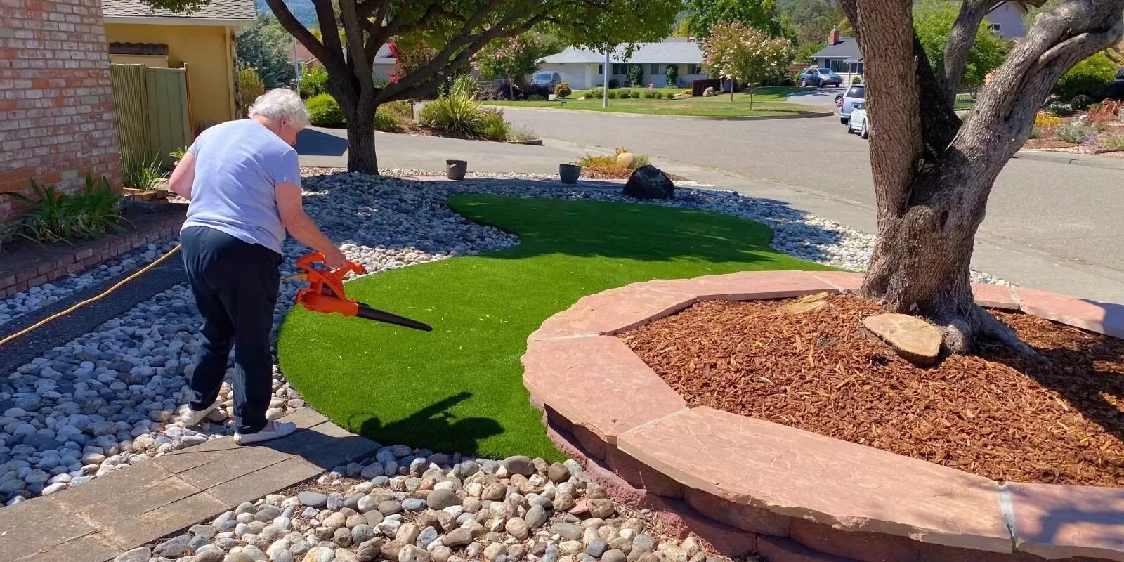 Person using a leaf blower to maintain artificial turf